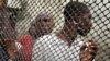 FILE - Prisoners line up inside Douala central prison in Cameroon.
