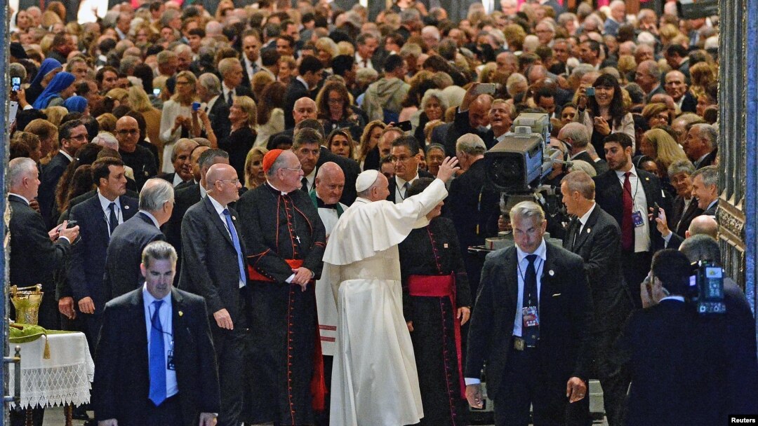 Pope Francis waves to gathered worshipers as he leaves St. Patrick's Cathedral after presiding over an evening prayer service, in New York, September 24, 2015.