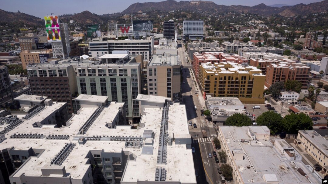 FILE - Apartment buildings line the streets in Los Angeles, July 30, 2018. Millennials are rejecting larger, expensive metropolises for smaller cities that offer more affordable housing and a lower other cost of living, according to a new report.