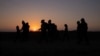 FILE - Migrants from Honduras and El Salvador walk towards the border wall after crossing the Rio Grande River into the United States from Mexico on a raft, in Penitas, Texas, March 26, 2021. 