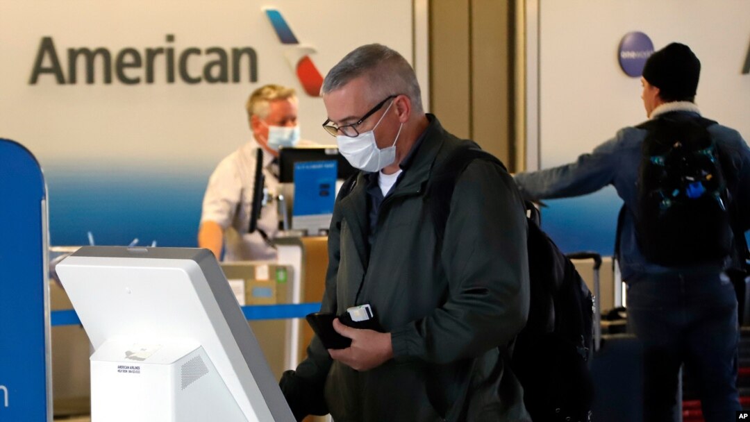 FILE - Travelers check in at the American Airline ticket counter at Greater Pittsburgh International Airport, May 7, 2020.