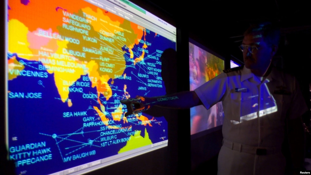 United States Navy lieutenant commander Kirk Benson, points at a map of the South China sea at the Tactical Flag Command Center (TFCC) of the 19,200-ton USS Blue Ridge in Manila, July 22, 2014.