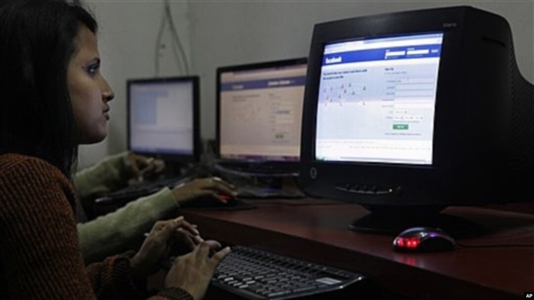 FILE - Young woman surfs Facebook page at an Internet cafe in Gauhati, India, Dec. 6, 2011.