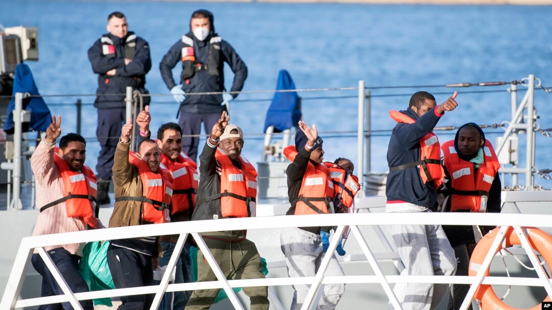 Migrants wave and give the v-sign as they disembark at Hay Wharf, Pieta, Malta, Jan. 9, 2019. 