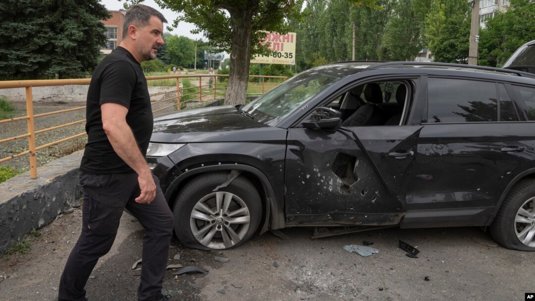 Slovyansk Mayor Vadym Lyakh passes by a car damaged by the Russian shelling in the city centre, in Slovyansk, Donetsk region, Ukraine, June 30, 2022. 