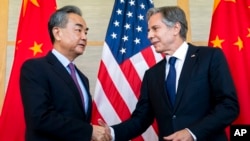 FILE - U.S. Secretary of State Antony Blinken, right, shakes hands with then-China's Foreign Minister Wang Yi during a meeting in Nusa Dua on the Indonesian resort island of Bali, July 9, 2022.