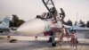 FILE - Russian air force pilots, assisted by ground personnel, climb into their fighter jet at Hemeimeem airbase, Syria, Oct. 22, 2015.