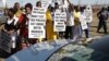 A group of protesters follow retired judge Ian Farlam and his team as they inspect the area where the bodies of mine workers were found after the shootings at Lonmin's platinum mine in Marikana near Rustenburg, South Africa, Oct. 1, 2012. 