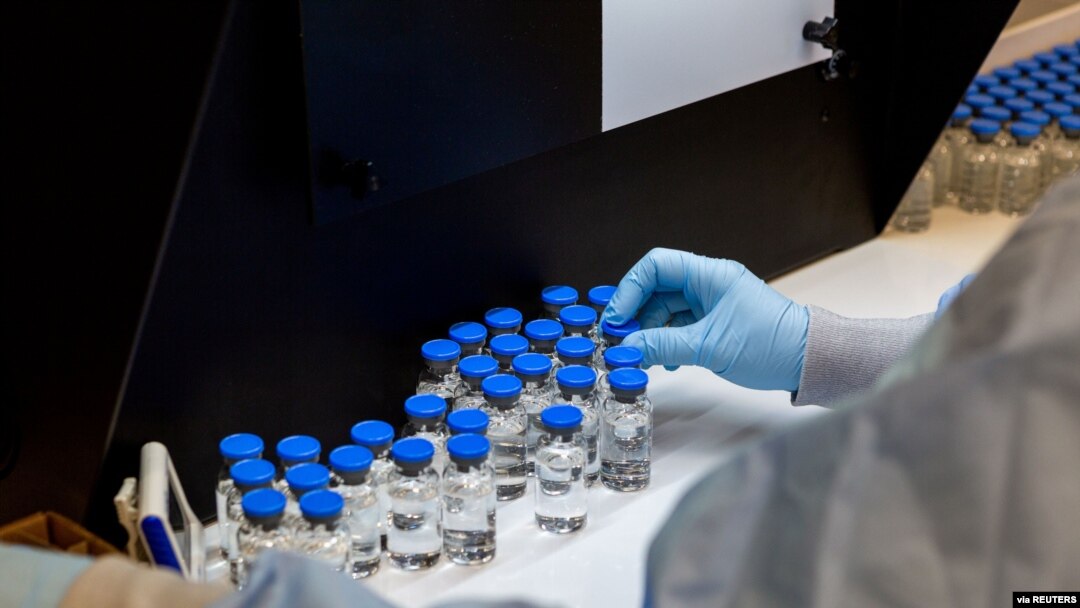 FILE - A lab technician inspects filled vials of coronavirus disease treatment drug remdesivir at a Gilead Sciences facility in La Verne, Calif., March 11, 2020.