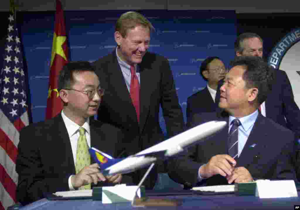 2001年10月2日,波音商用飞机CEO Alan Mulally, 中国南方航空公司的Li Fenghua 和海南航空公司的任卫东(译音)在美国商务部交谈。中国当时购买了30架波音737客机