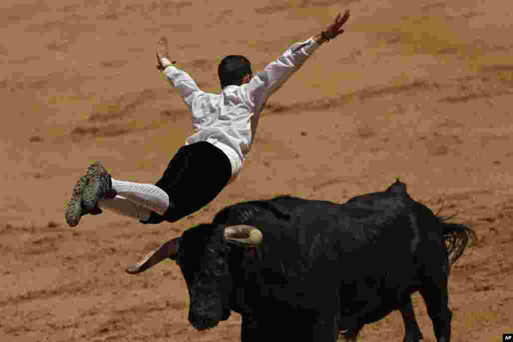 A "recortador" jumps over a bull during a "recortadores" festival at Las Ventas bullring in Madrid, Spain.