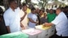 The returning officer for Mvita Constituency, Mombasa, Gabriel Mwalenga, right, explains to registered voters how the ballot boxes will be used in the forthcoming general elections during an election mock voting exercise organized. 