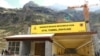 FILE - Laborers work next to the newly constructed Atal Tunnel on the Leh-Manali highway in Sissu village in Lahaul and Spiti district in the northern state of Himachal Pradesh, India, Sept. 22, 2020. 