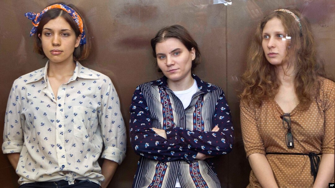 FILE - Pussy Riot members, from left, Nadezhda Tolokonnikova, Yekaterina Samutsevich and Maria Alekhina are seen in a glass cage in a court room during their trial in Moscow last year.