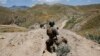 FILE - An Afghan border policeman is seen patrolling a section of the frontier between Afghanistan and Pakistan.