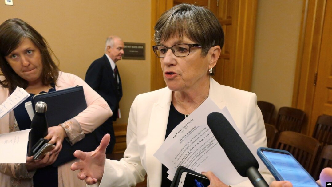 FILE - Kansas Gov. Laura Kelly speaks with reporters at the Statehouse in Topeka, Kansas, June 5, 2019.