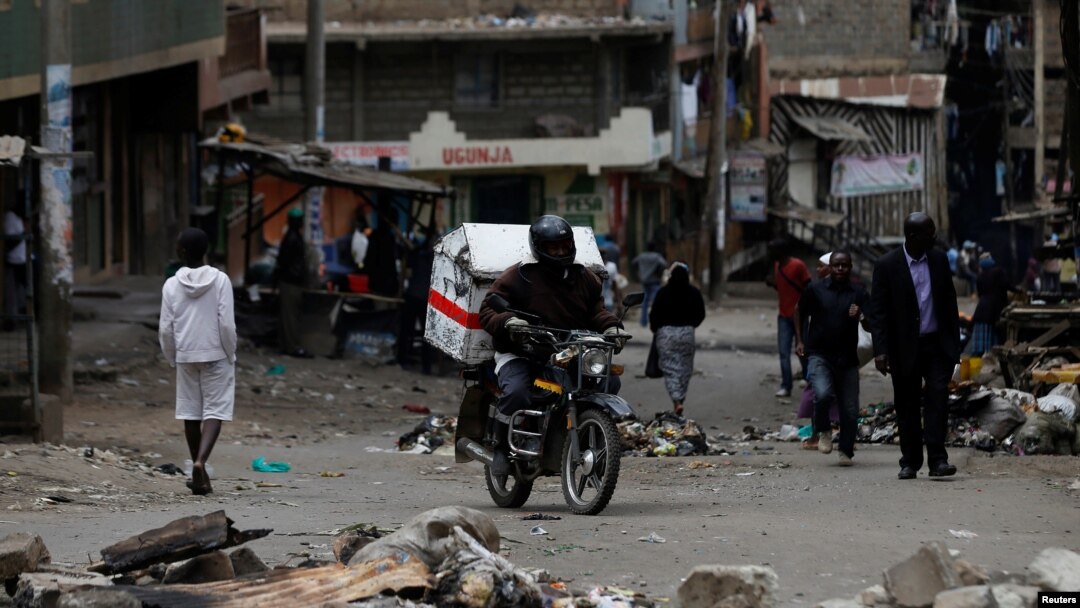 A motorcyclist drives through obstacles placed on a street by supporters of opposition leader Raila Odinga during the latest protests in Mathare, Nairobi, Kenya, August 14, 2017. 