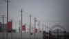 FILE - Chinese flags line on a road leading to a facility believed to be a re-education camp where mostly Muslim ethnic minorities are detained, on the outskirts of Hotan in China's northwestern Xinjiang region, May 31, 2019.