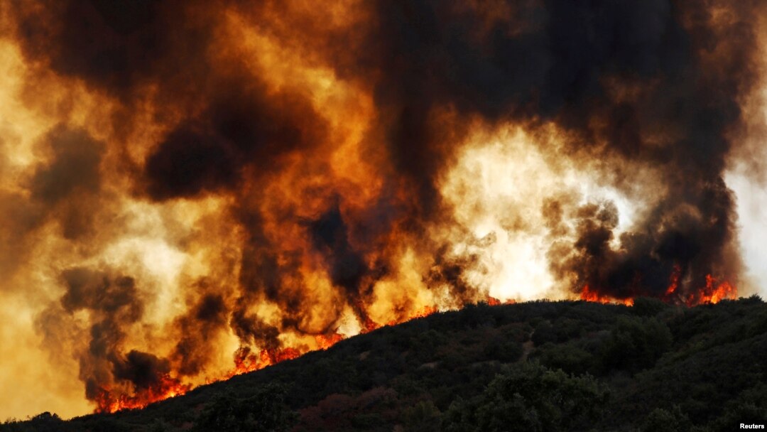 Wind-driven flames roll over a hill towards homes during the River Fire (Mendocino Complex) near Lakeport, California, U.S., Aug. 2, 2018. 