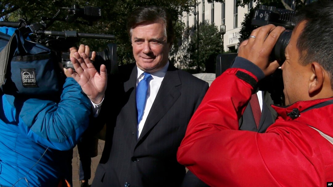 Paul Manafort makes his way through television cameras as he walks from Federal District Court in Washington, Oct. 30, 2017. 