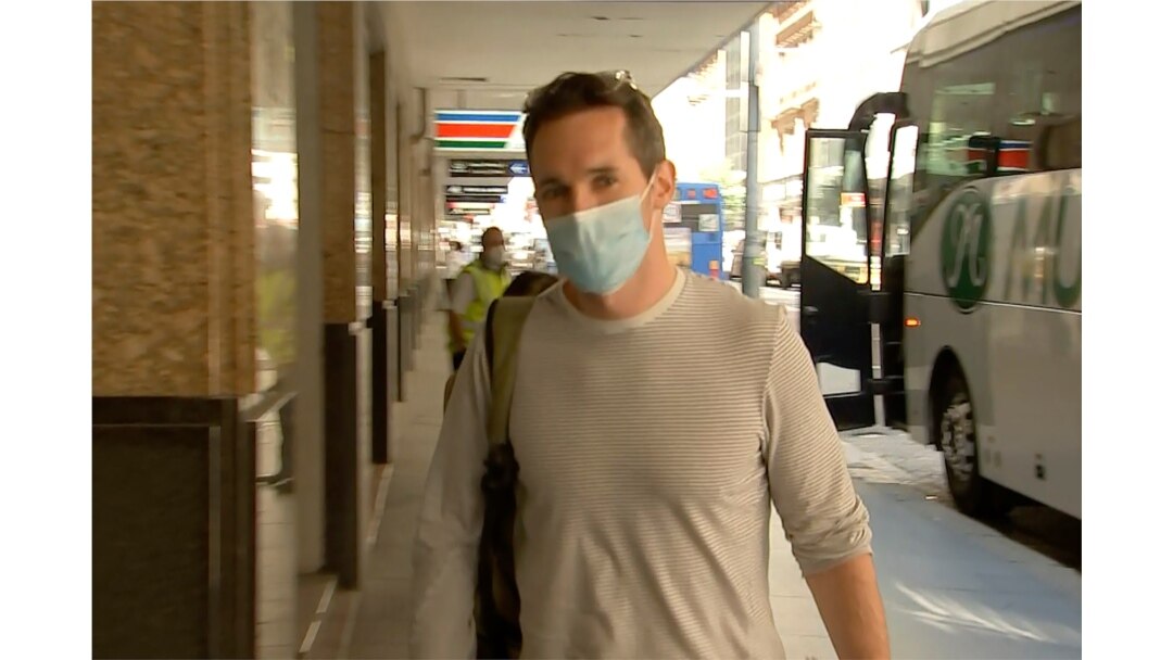 FILE - Australian Broadcasting Corp. journalist Bill Birtles walks into a hotel for quarantine in Sydney, Australia, Sept. 8, 2020.