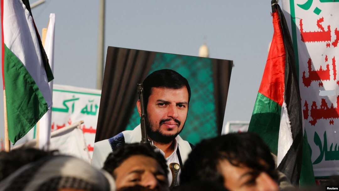 A person holds a placard with a picture of Yemen's Houthi movement leader, Abdul-Malik al-Houthi, as supporters rally to denounce airstrikes launched by the U.S. and Britain on Houthi targets, in Sanaa, Yemen, on Jan. 12, 2024.