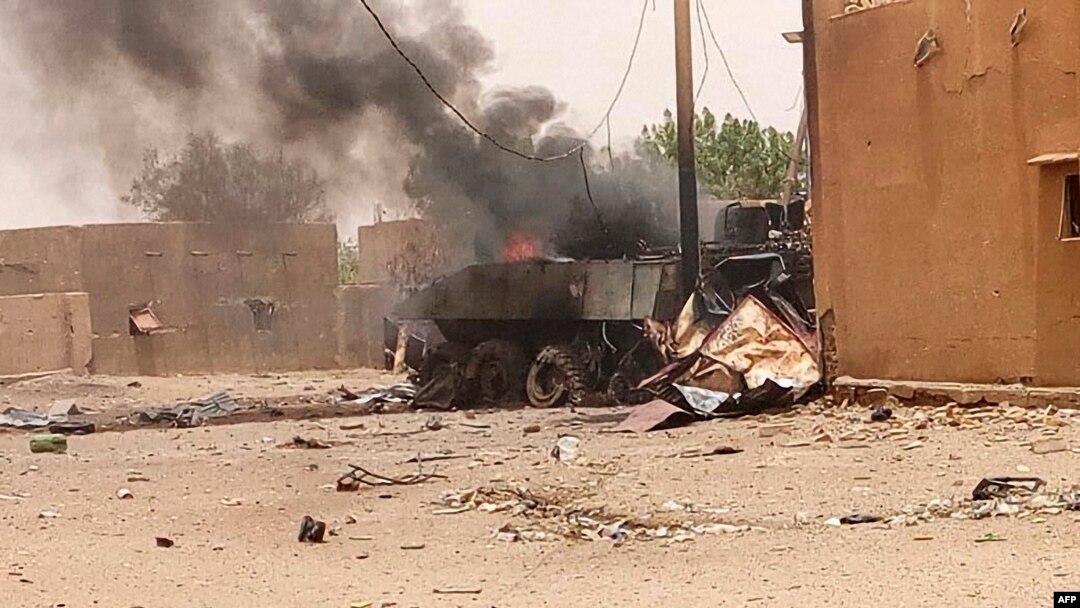 FILE - Smoke and flames ascend from an army armored vehicle in Gao, northwestern Mali, following an explosion on July 1, 2018.
