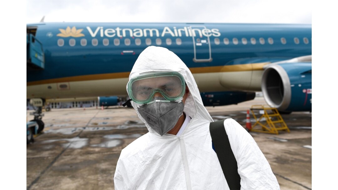 In this file photo taken on March 3, 2020 a worker wearing a protective suit prepares to disinfect a Vietnam Airlines plane amid concerns of the spread of the coronavirus at Noi Bai International Airport in Hanoi.