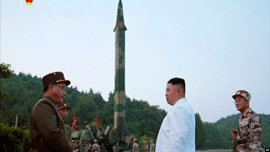 김정은 북한 국무위원장(가운데)이 새로 개발한 정밀유도 탄도미사일 시험발사를 참관했다고, 관영 조선중앙통신이 지난 5월 보도했다. 김 위원장 뒤로 미사일 발사대 모습이 보인다. 