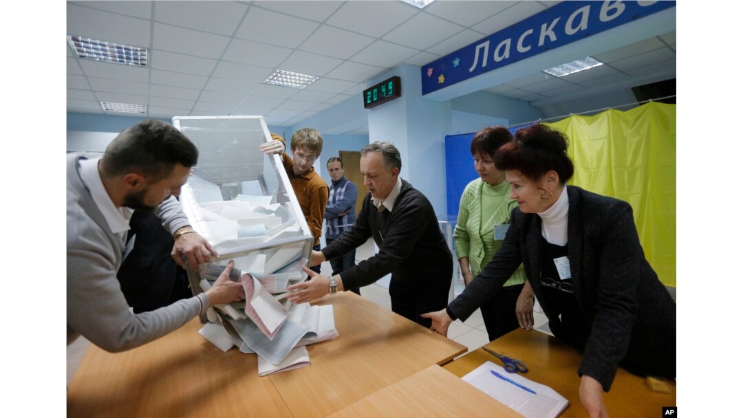 Members of a local election commission open a ballot box to count votes after a day of election at a polling station in Kiev, Ukraine, Oct. 25, 2015.