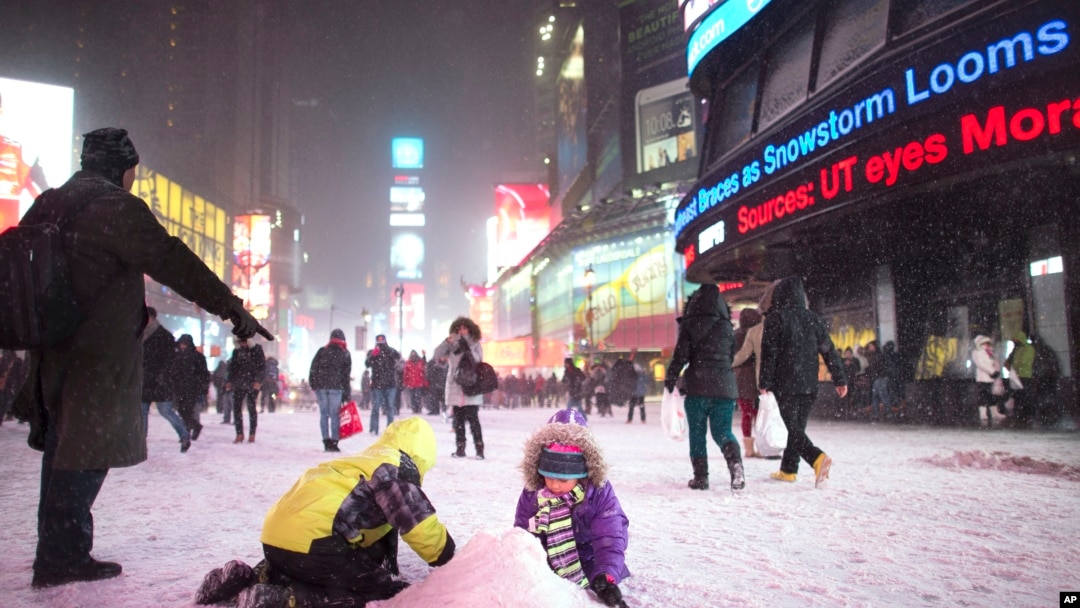 Children make a snow pile in Times Square, during a snowstorm, Thursday, Jan. 2, 2014, in New York. 