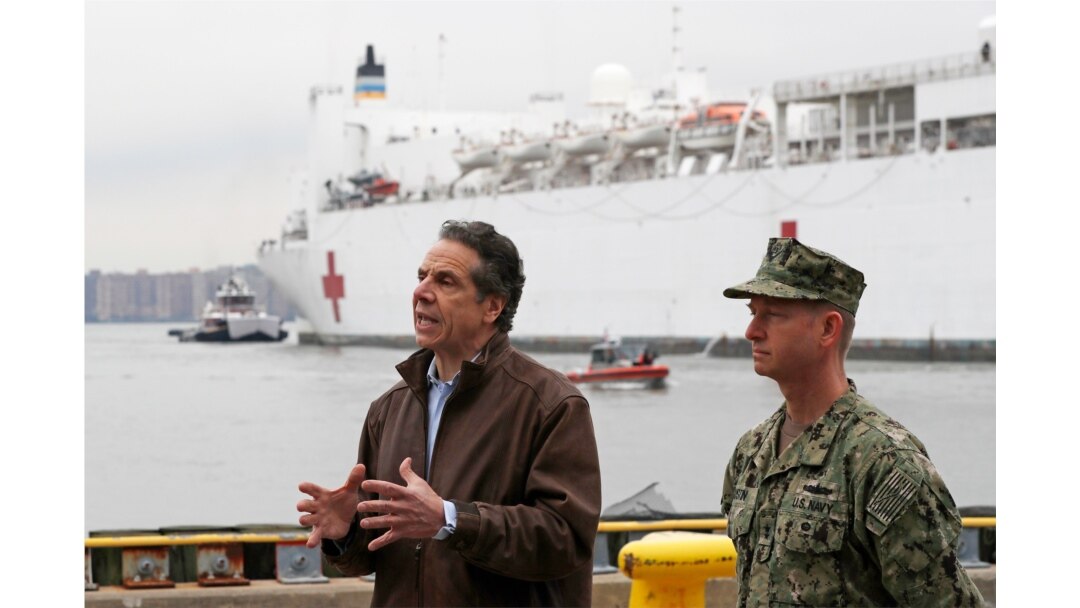 New York Gov. Andrew Cuomo, left, speaks as he stands beside Rear Adm. John B. Mustin after the arrival of the USNS Comfort, March 30, 2020, at Pier 90 in New York.