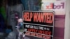 FILE - A sign seeking workers hangs in the window of a shop along Main Street in Deadwood, S.D., May 26, 2021. 