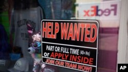 FILE - A sign seeking workers hangs in the window of a shop along Main Street in Deadwood, S.D., May 26, 2021. 
