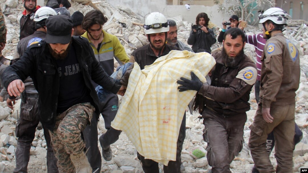 FILE - Members of the Syrian civil defense, known as the White Helmets, remove a victim from the rubble of a destroyed building following a reported airstrike in the northwestern city of Idlib, March 15, 2017.