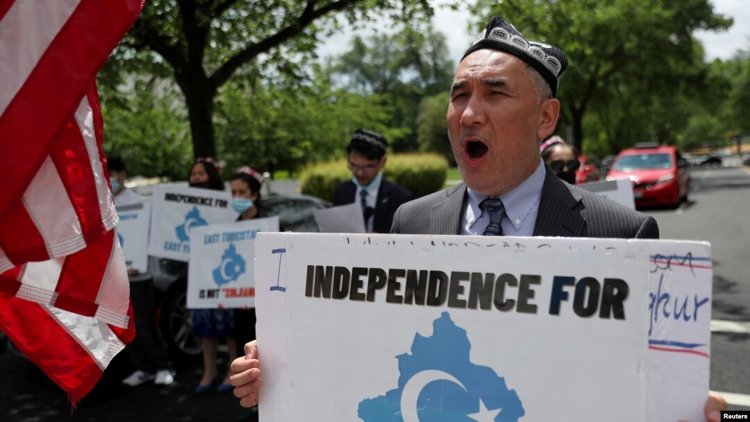 FILE - Demonstrators hold a protest in front of the State Department to urge the US and the international community to take action against China's treatment of the Uyghur people, May 5, 2021.