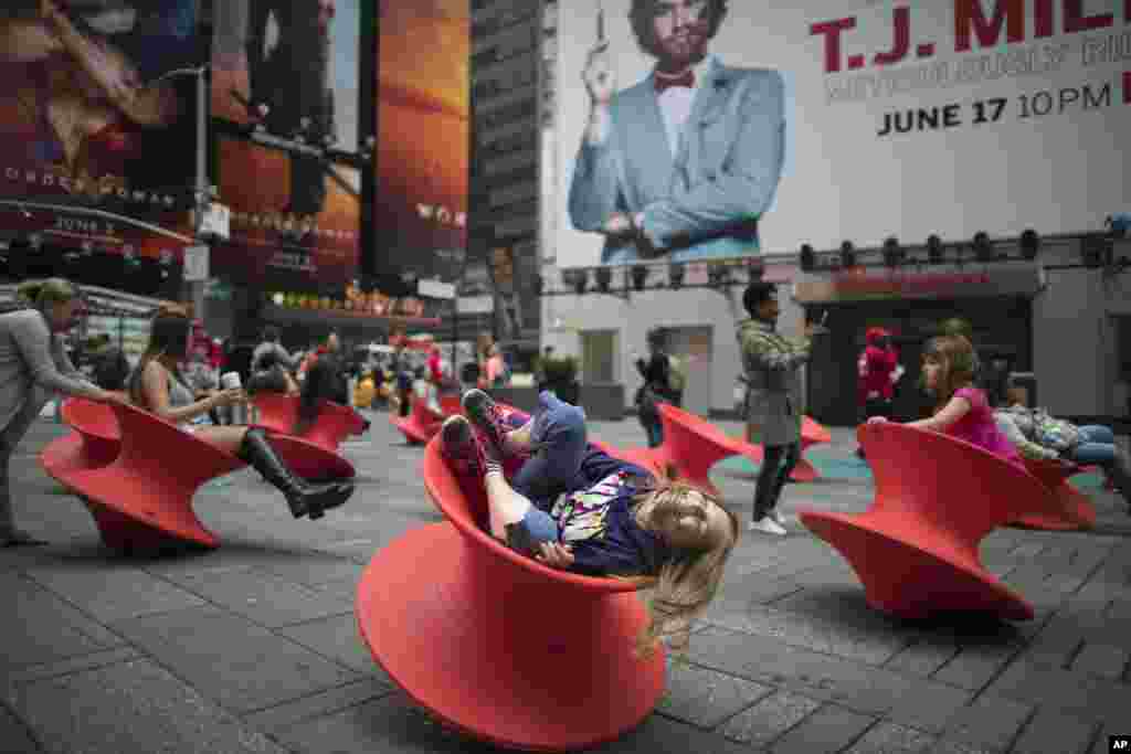 People enjoy the spinning chairs in New York's Times Square.