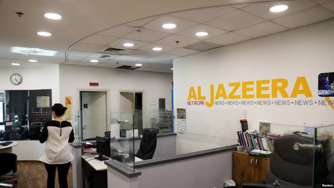 FILE - An employee walks inside an office of Qatar-based Al-Jazeera network in Jerusalem, June 13, 2017.