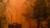 FILE - Firetrucks respond to a bushfire in Werombi, 50 kilometers southwest of Sydney, Dec. 6, 2019.
