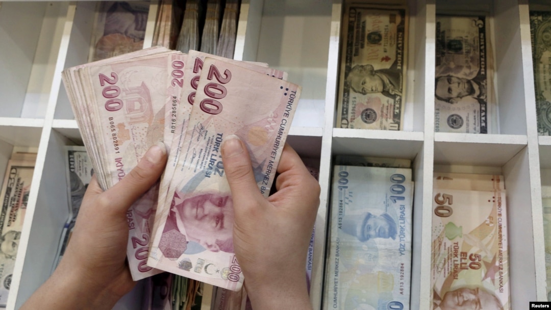 FILE - A money changer counts Turkish lira at an currency exchange office in Istanbul, Aug. 21, 2015. 