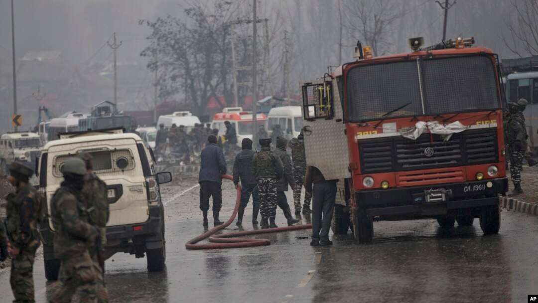 Indian firemen spray water on a road to wash away blood after an explosion in Pampore, Indian-controlled Kashmir, Thursday, Feb. 14, 2019. 