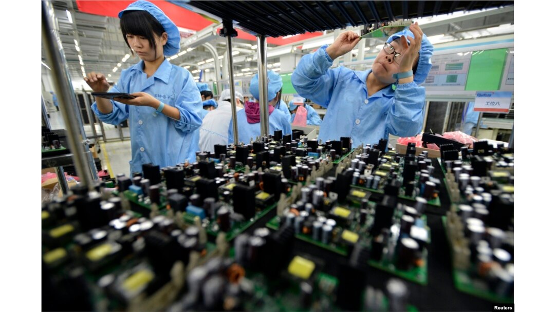 FILE - Employees work on a FiberHome Technologies Group factory production line in Wuhan, Hubei province, China, July 27, 2015.