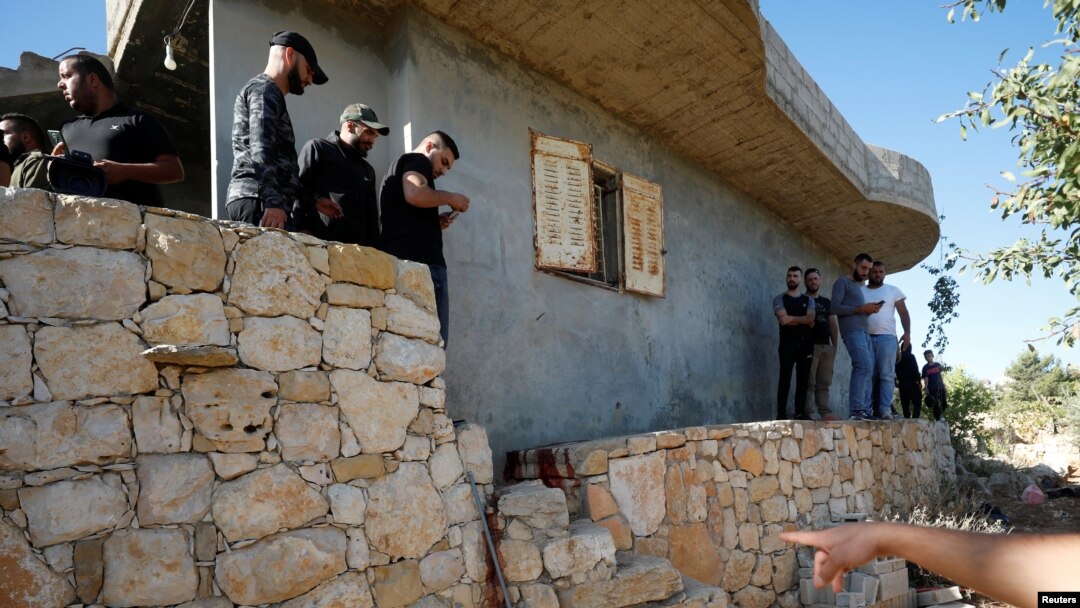 People check the scene where Palestinians were killed by Israeli forces during a raid, in Beit Anan in the Israeli-occupied West Bank, Sept. 26, 2021.