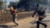 A policeman chases away a farmer during a protest against the newly passed farm bills at Singhu border near Delhi, India, Nov. 27, 2020.