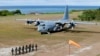 FILE - Philippine troops march as a Philippine Air Force C-130 transport plane carrying Philippine Defense Secretary Delfin Lorenzana, Armed Forces Chief Gen. Eduardo Ano and other officials, sits on the tarmac at the Philippine-claimed Thitu Island off the disputed Spratlys chain of islands in the South China Sea, April 21, 2017 in western Philippines. 