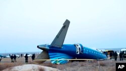 In this photo taken from a video released by the administration of Mangystau region, a part of Azerbaijan Airlines' Embraer 190 lies on the ground near the airport of Aktau, Kazakhstan, Dec. 26, 2024.