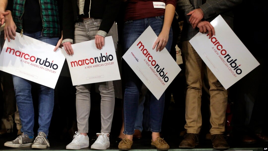 Supporters of Republican presidential candidate Senator Marco Rubio stand on a stage, holding placards before a campaign event in Exeter, New Hampshire, Feb. 2, 2016.