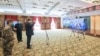 资料照：戴着口罩的中国国家主席习近平视察火神山医院时通过视频向新冠病毒感染者和医护人员招手。（2020年3月10日）