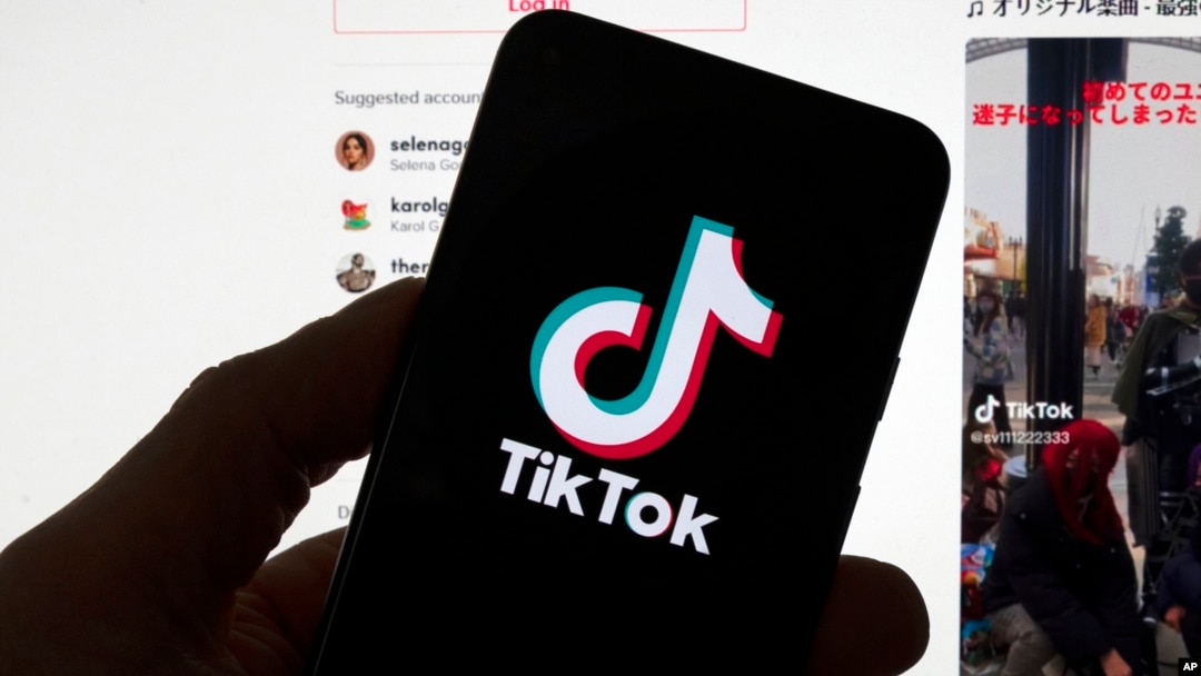 FILE - The TikTok logo is displayed on a mobile phone in front of a computer screen displaying a TikTok home page on March 18, 2023, in Boston, Massachusetts.