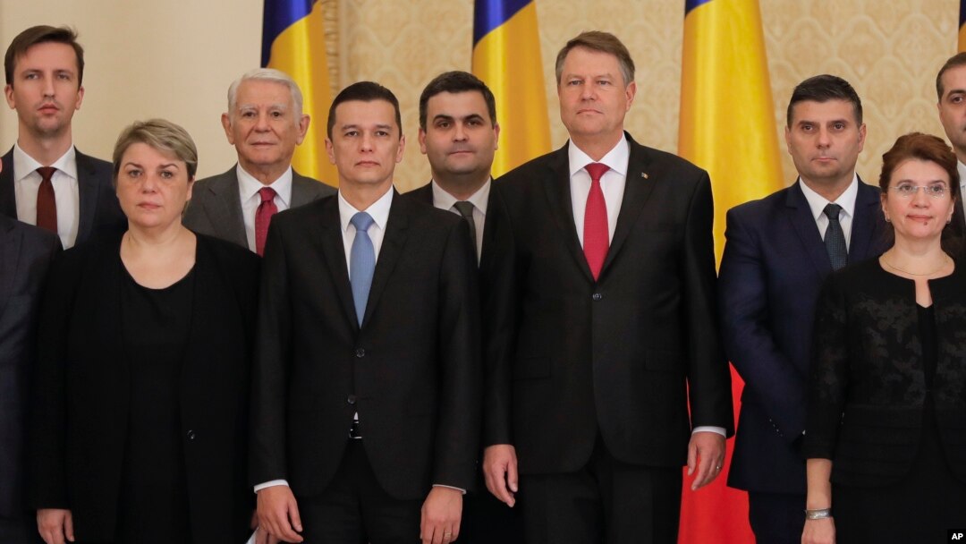 Romanian Prime Minister Sorin Grindeanu, center left, poses for the media next to Romanian President Klaus Iohannis after the swearing in ceremony for his cabinet, in Bucharest, Romania, Jan. 4, 2017.